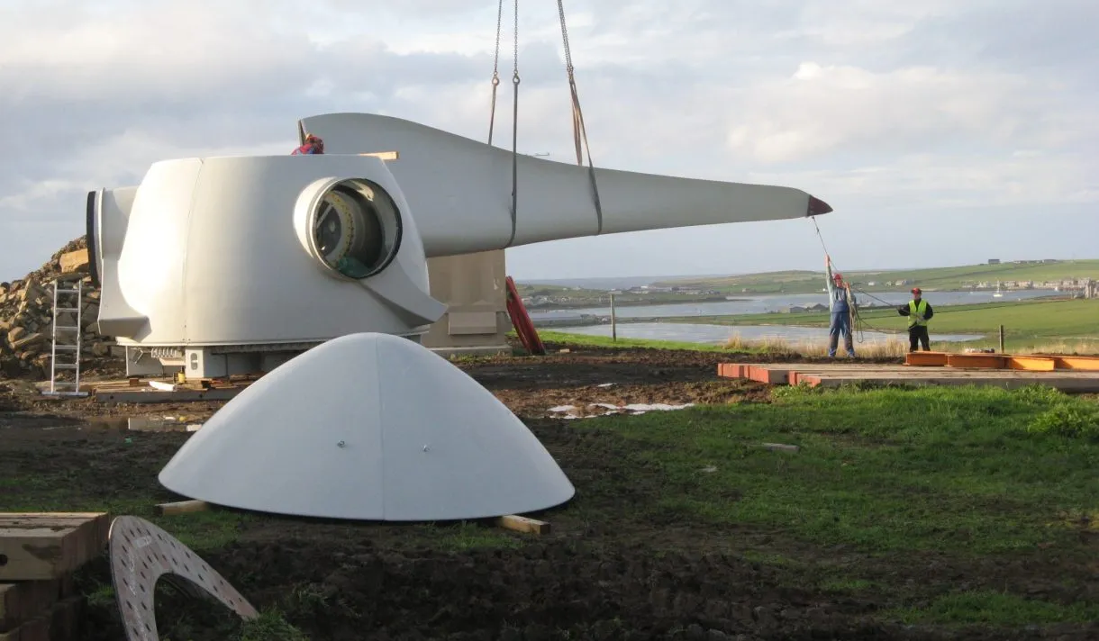 Two workers constructing a community-owned turbine