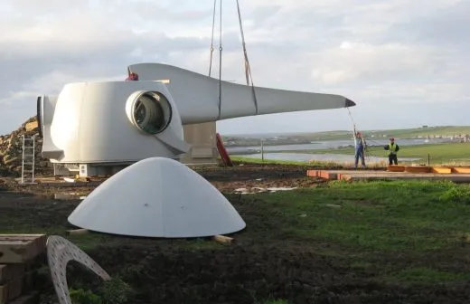 Two workers constructing a community-owned turbine