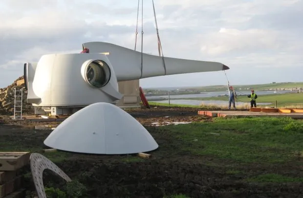 Two workers constructing a community-owned turbine